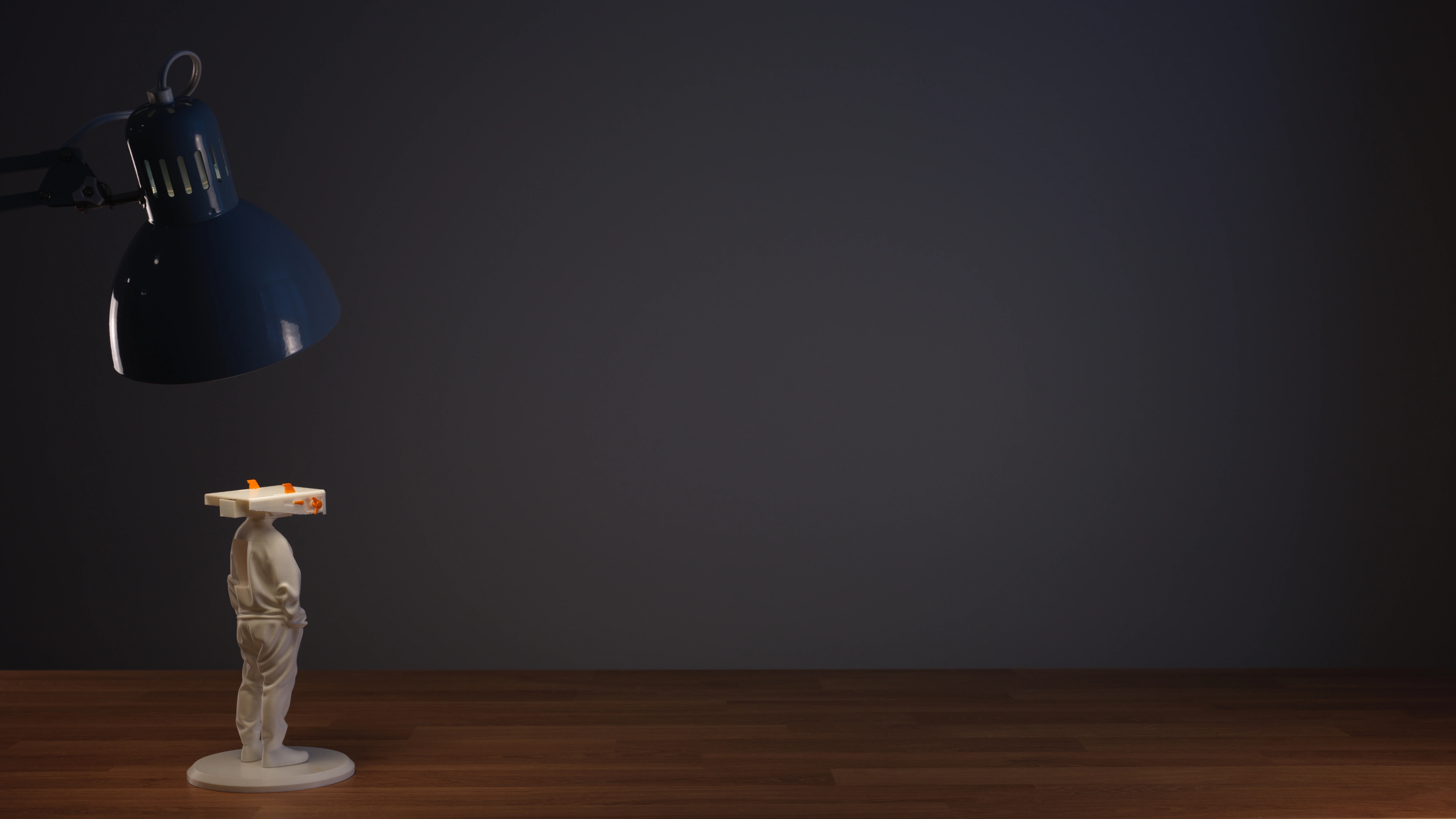 Heartman standing beneath a desk lamp